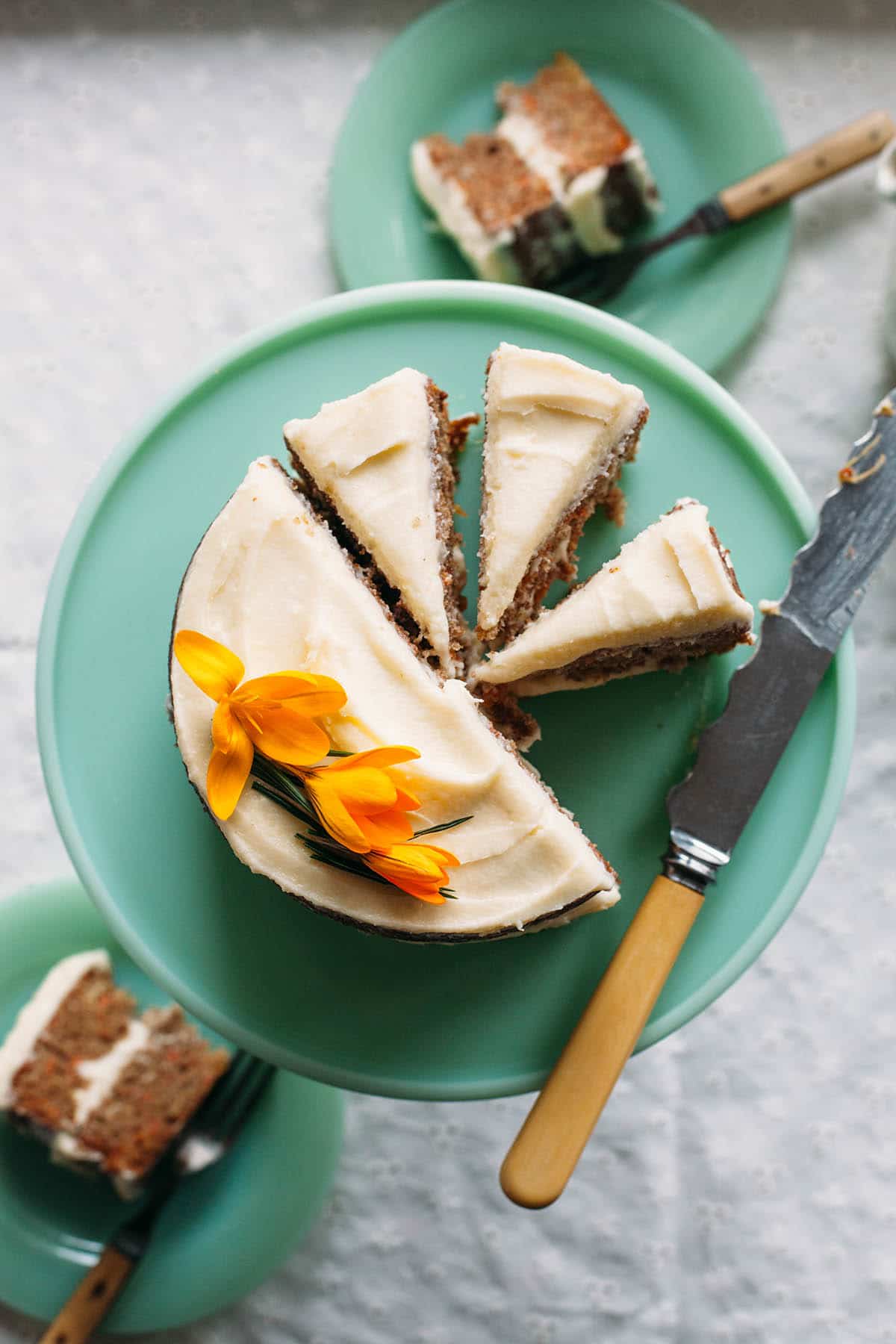 Sliced spiced carrot cake with pineapple on a cake stand.