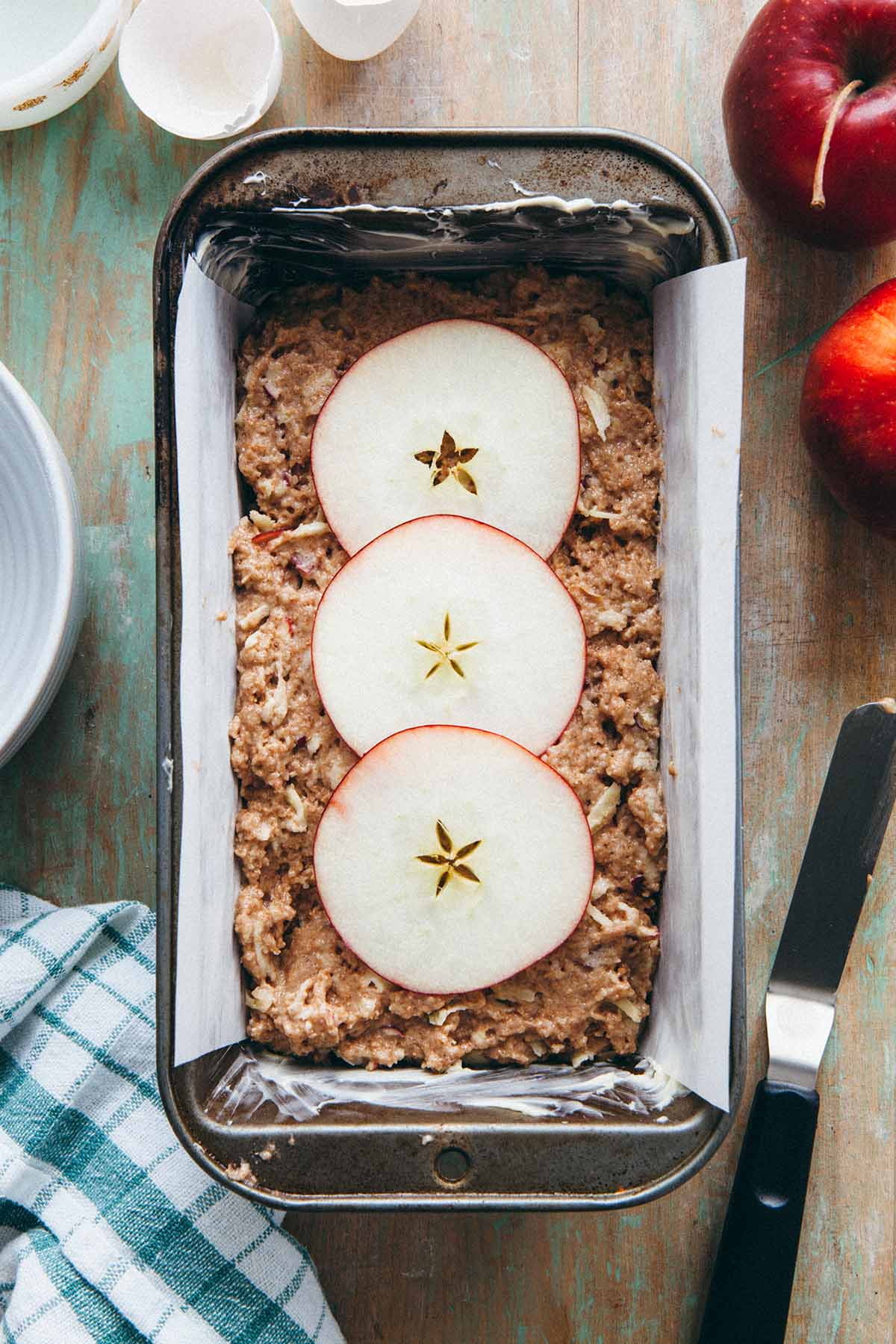 Unbaked apple loaf with three thin apple slices on top.