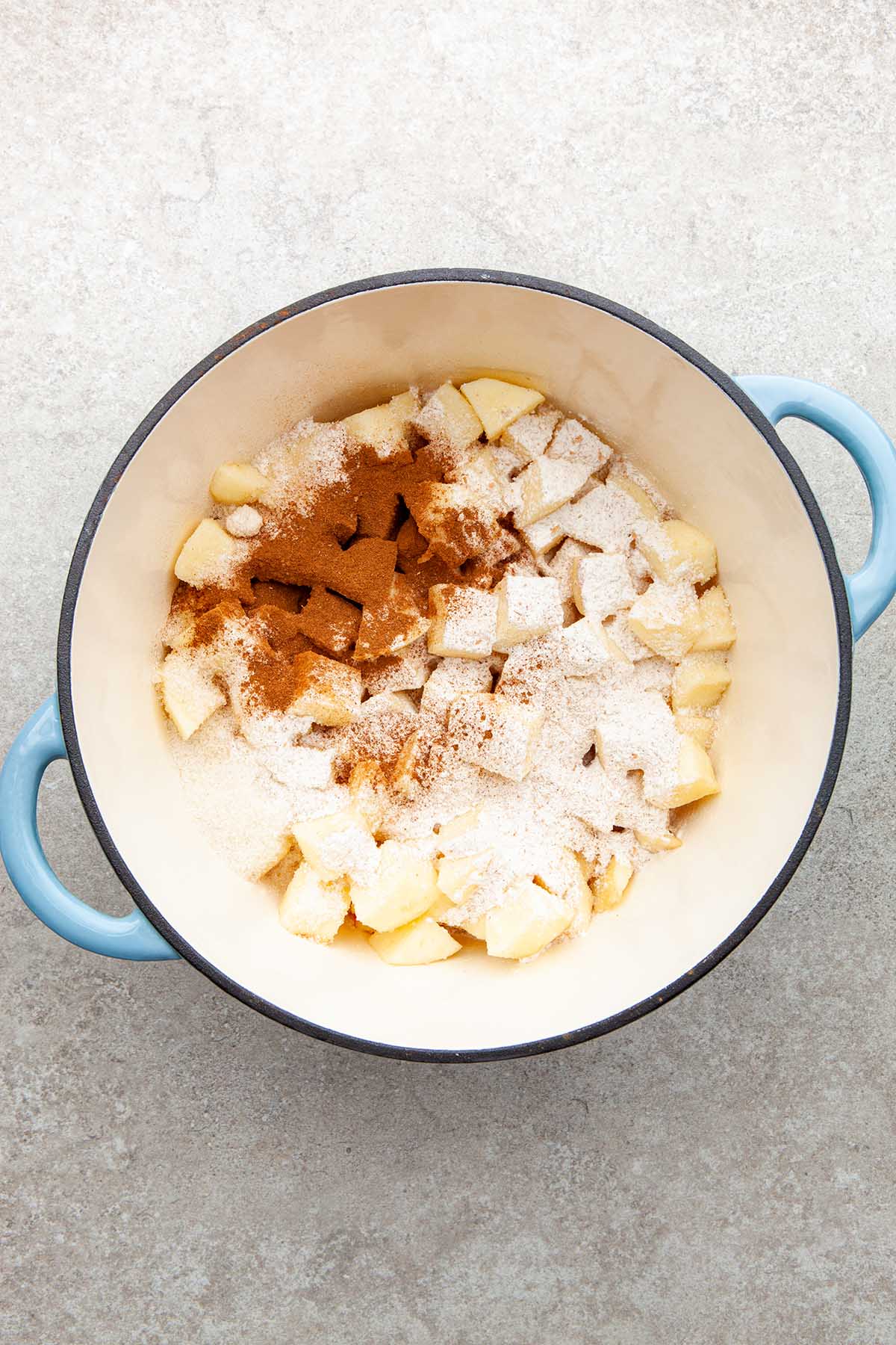 Cubes apples, cinnamon, sugar and flour in a pot.