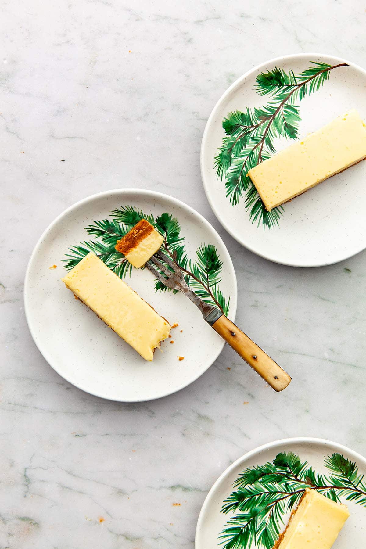 Three plates of condensed milk lemon slices, one with a bite cut out on a fork.