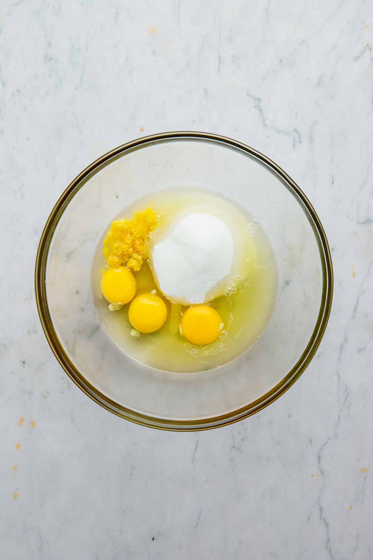Eggs, lemon zest and juice, sugar, and salt in a large glass bowl.